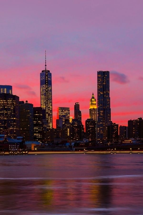 New York City Skyline at sunset. With One World Trade Center and the Empire State Building visible.