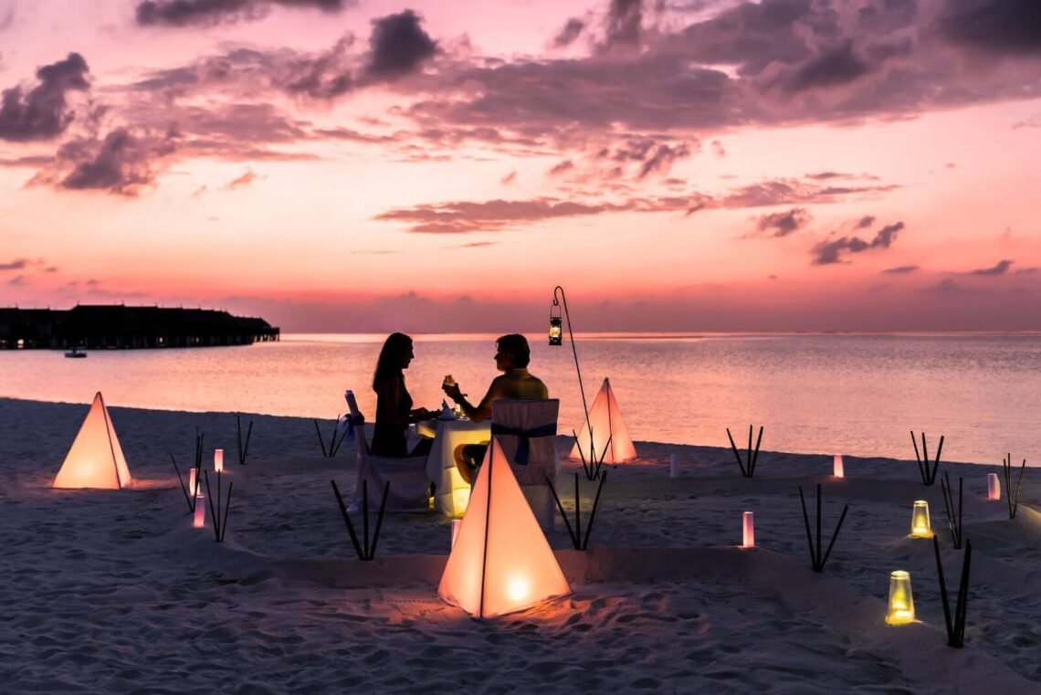 hidden gems for a romantic getaway - couple on the beach with a glass of with and a beautiful sunset