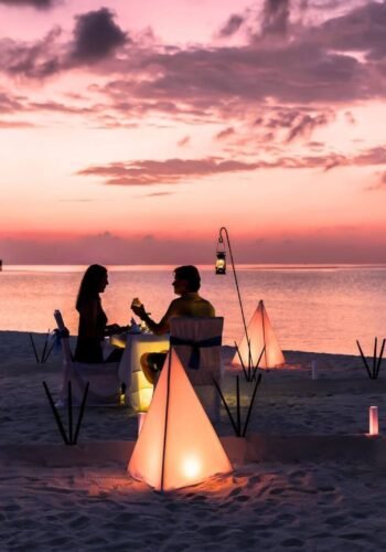 hidden gems for a romantic getaway - couple on the beach with a glass of with and a beautiful sunset