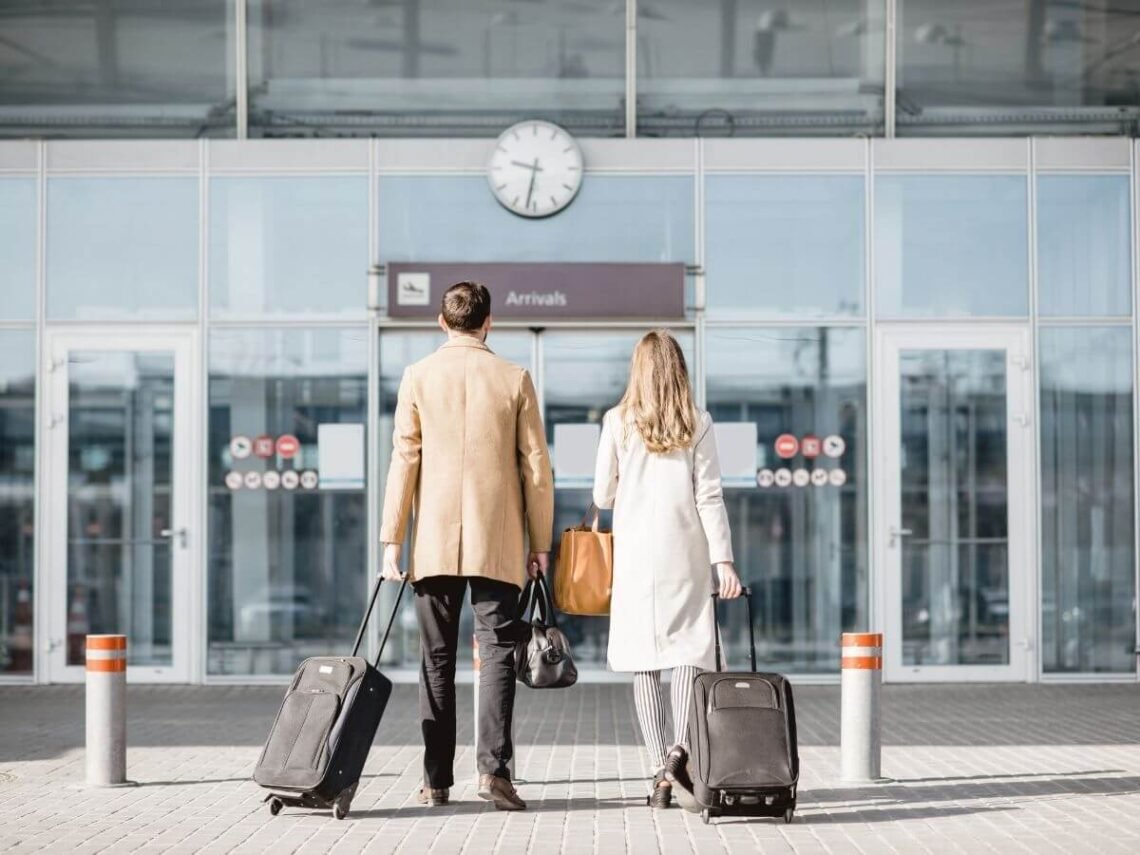 lady and gentleman walking into the airport for there next adventure