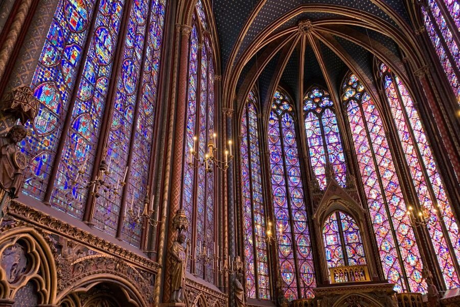 Stained glass windows of Sainte-Chapelle, the colours purple, red, and blue standing out in intricate designs.