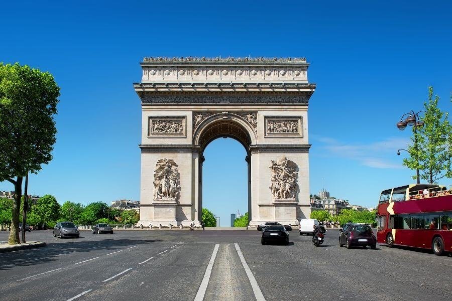 Arc de triomphe with cars and bus entering round-a-bout