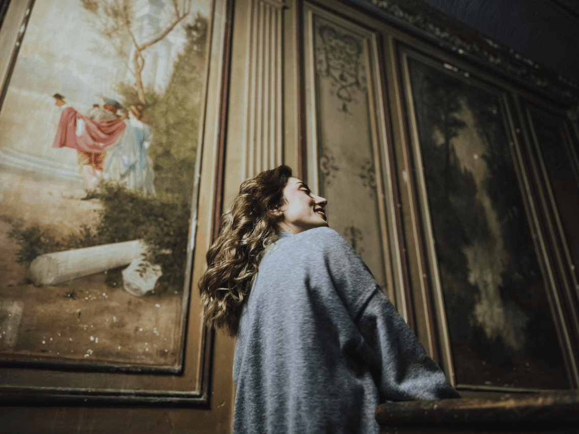 solo woman enjoying art gallery smiling - Soft Travel Guide