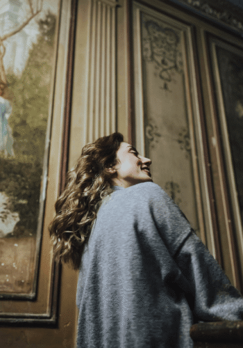 solo woman enjoying art gallery smiling - Soft Travel Guide