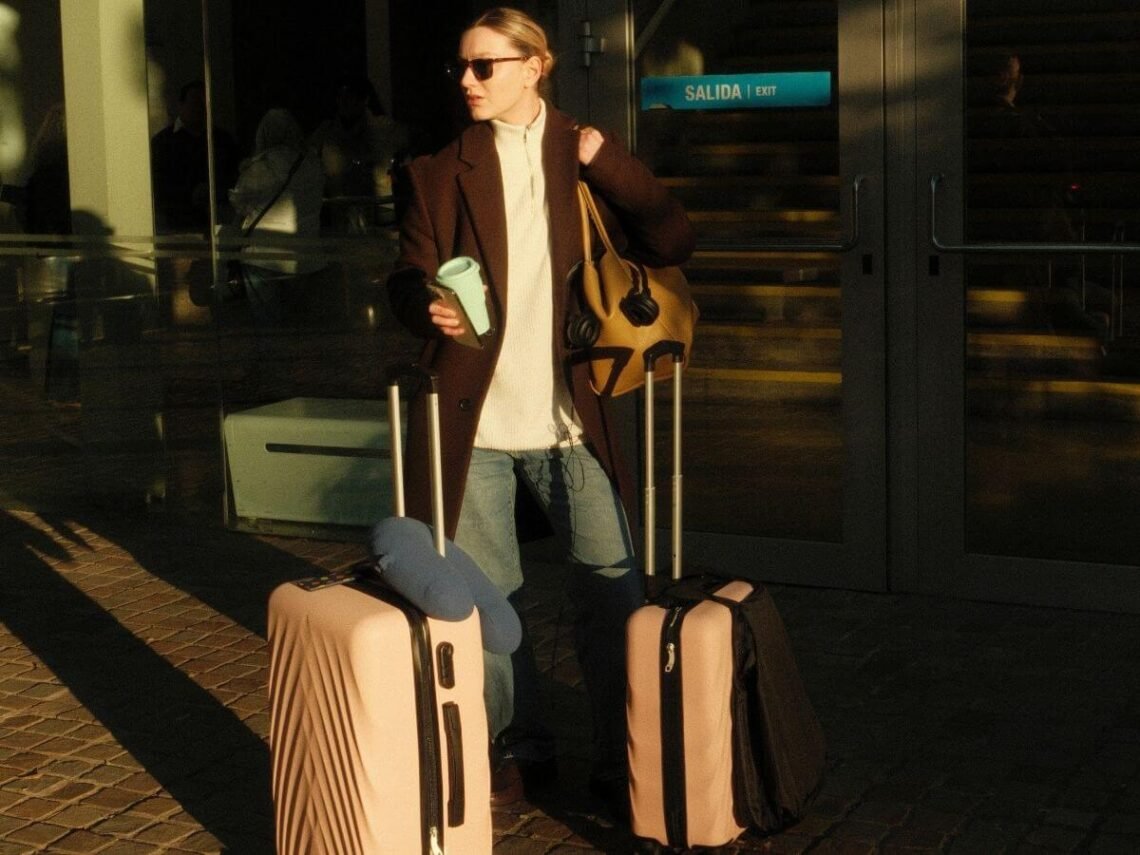 woman at airport with suitcases. winter airport outfits.